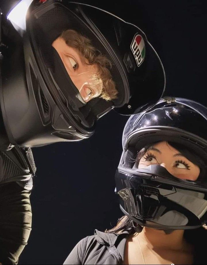 two people with helmets on their heads are facing each other