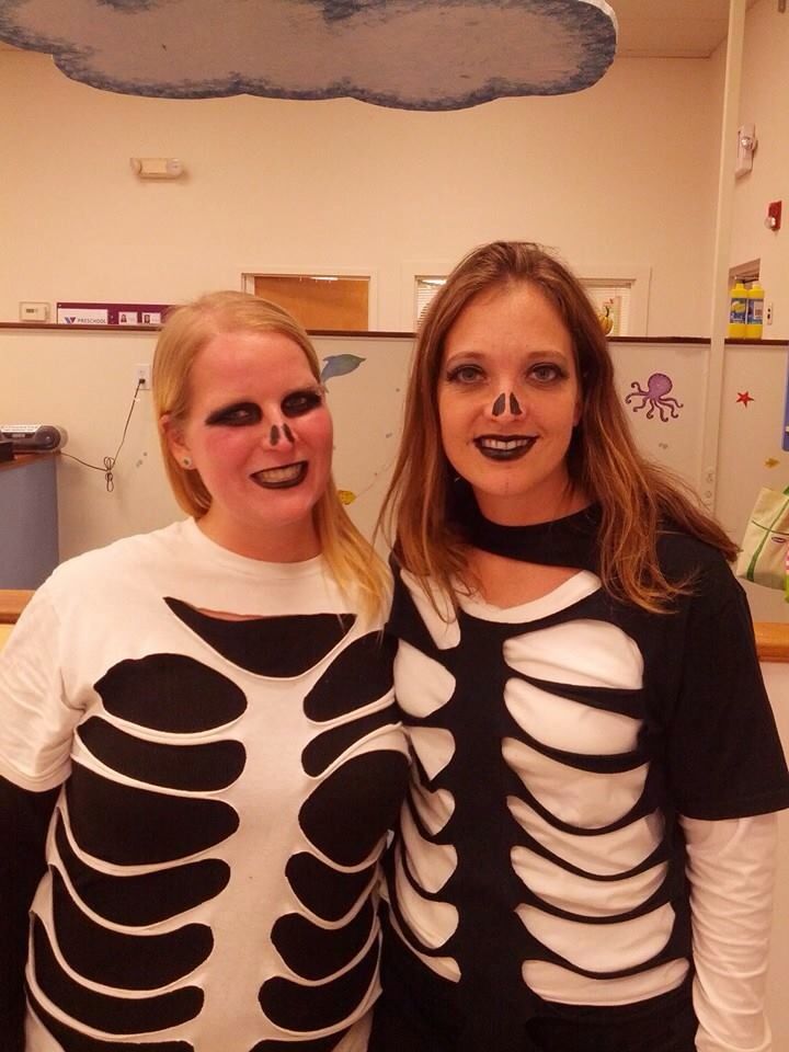 two women in skeleton costumes pose for the camera