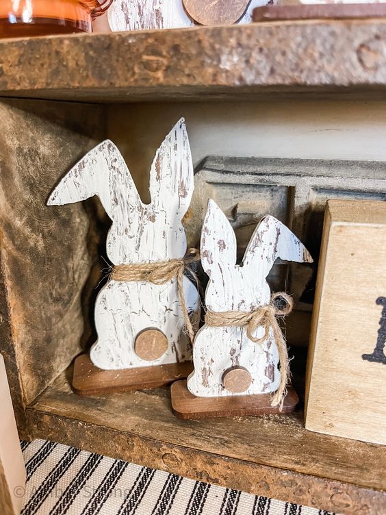 two wooden rabbits sitting on top of a shelf