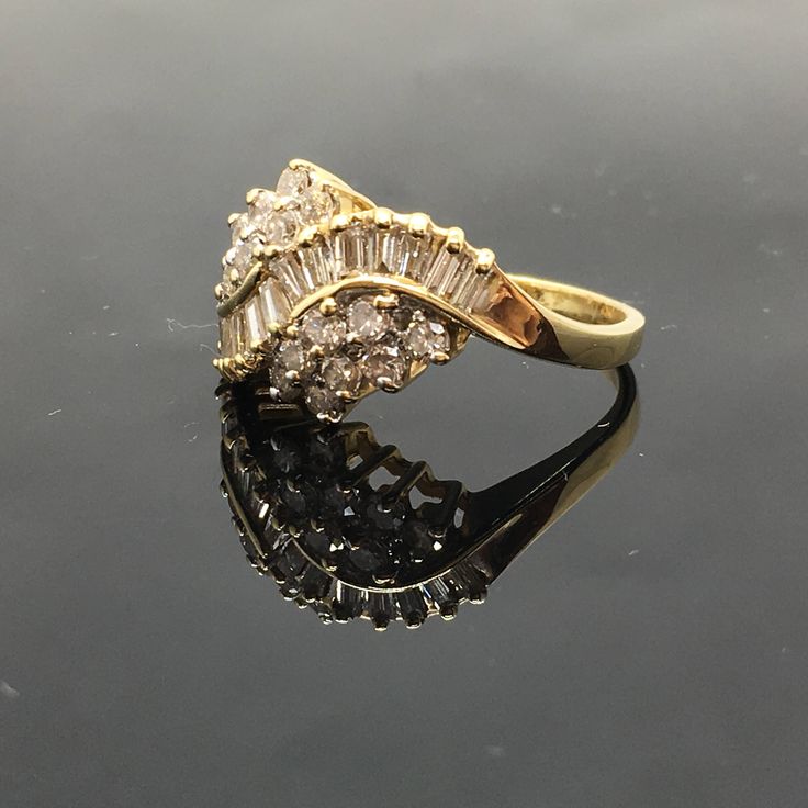 14K Diamond Cluster Ring METAL: 14K Yellow Gold TOTAL WEIGHT: 4.1g DIAMONDS: Round Brilliant Cut and Baguette Diamonds COLOR: H/I CLARITY: SI1 TOTAL WEIGHT: 1.00 ct SIZE: Ladies size 5-9. Please indicate your ring size at checkout. DESCRIPTION: Vintage style diamond cluster ring. The ring is yellow gold with round and baguette diamonds. The top width is 11.8mm and a height of 6.2mm. Gold Baguette Rings For Formal Occasions, Classic Gold Baguette Ring, Classic Gold Baguette Diamond Ring, Anniversary Cluster Ring With Baguette Diamonds, Gold Baguette Ring For Anniversary, Formal Yellow Gold Cluster Ring With Baguette Diamonds, Elegant Gold Cluster Ring With Baguette Diamonds, Gold Cluster Rings With Baguette Diamonds, Vintage Yellow Gold Rings With Baguette Diamonds