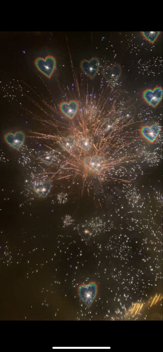 fireworks are in the sky with heart shaped bubbles