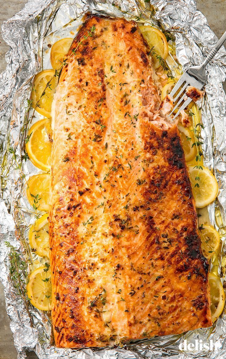 a piece of fish on foil with lemons and herbs