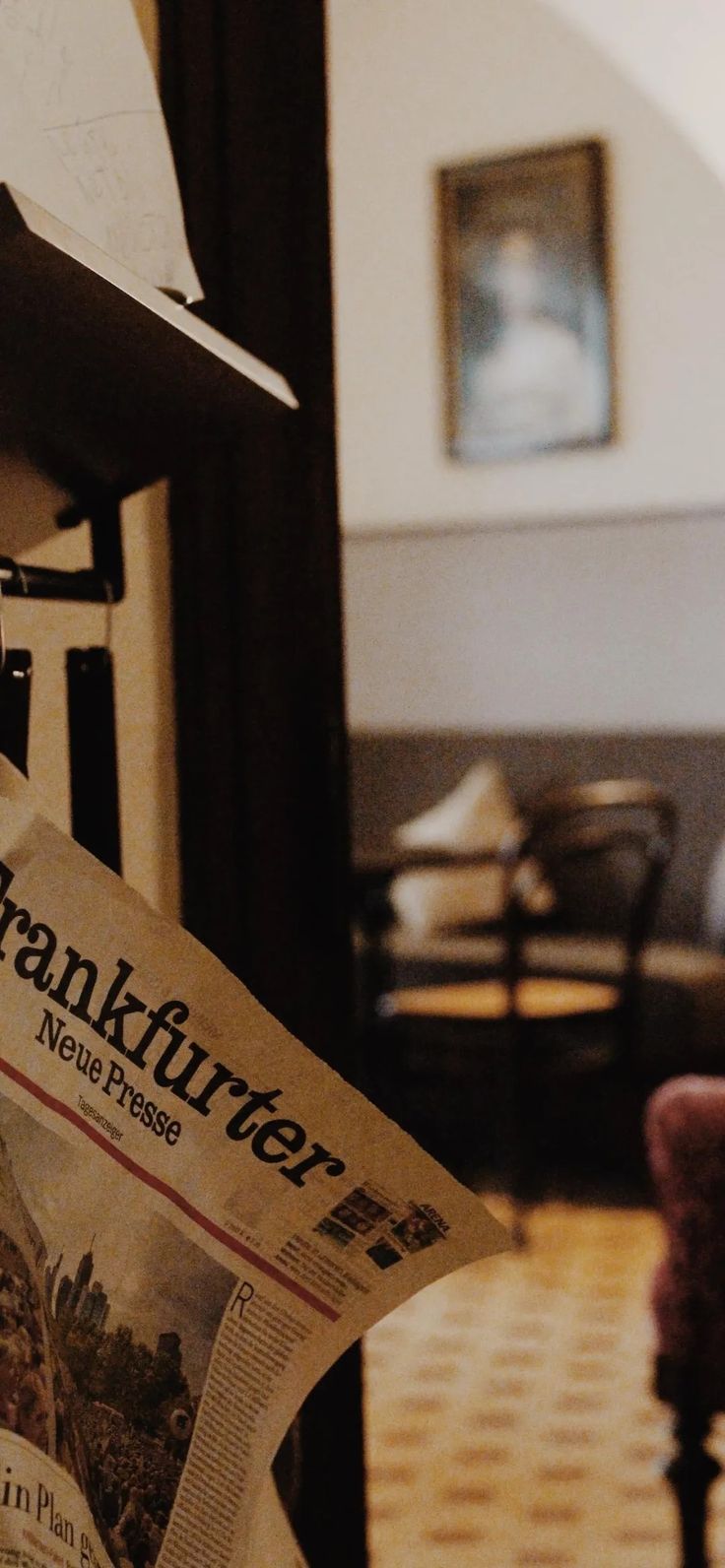 a newspaper is laying on top of a chair in a room with chairs and tables