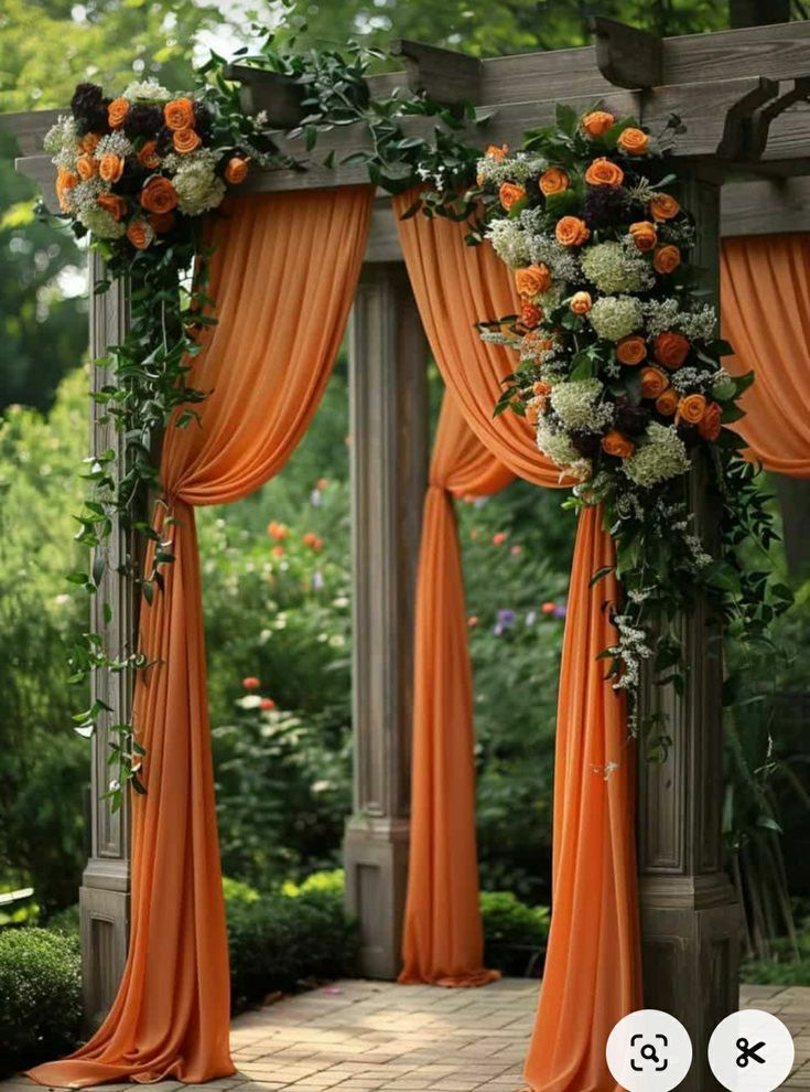 an outdoor wedding ceremony with orange drapes and flowers