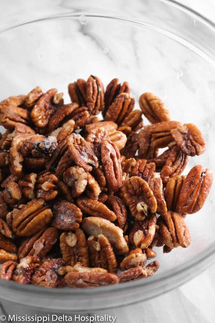 a glass bowl filled with nuts on top of a marble counter