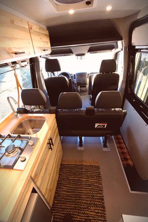 an interior view of a camper van with the kitchen and living room in it