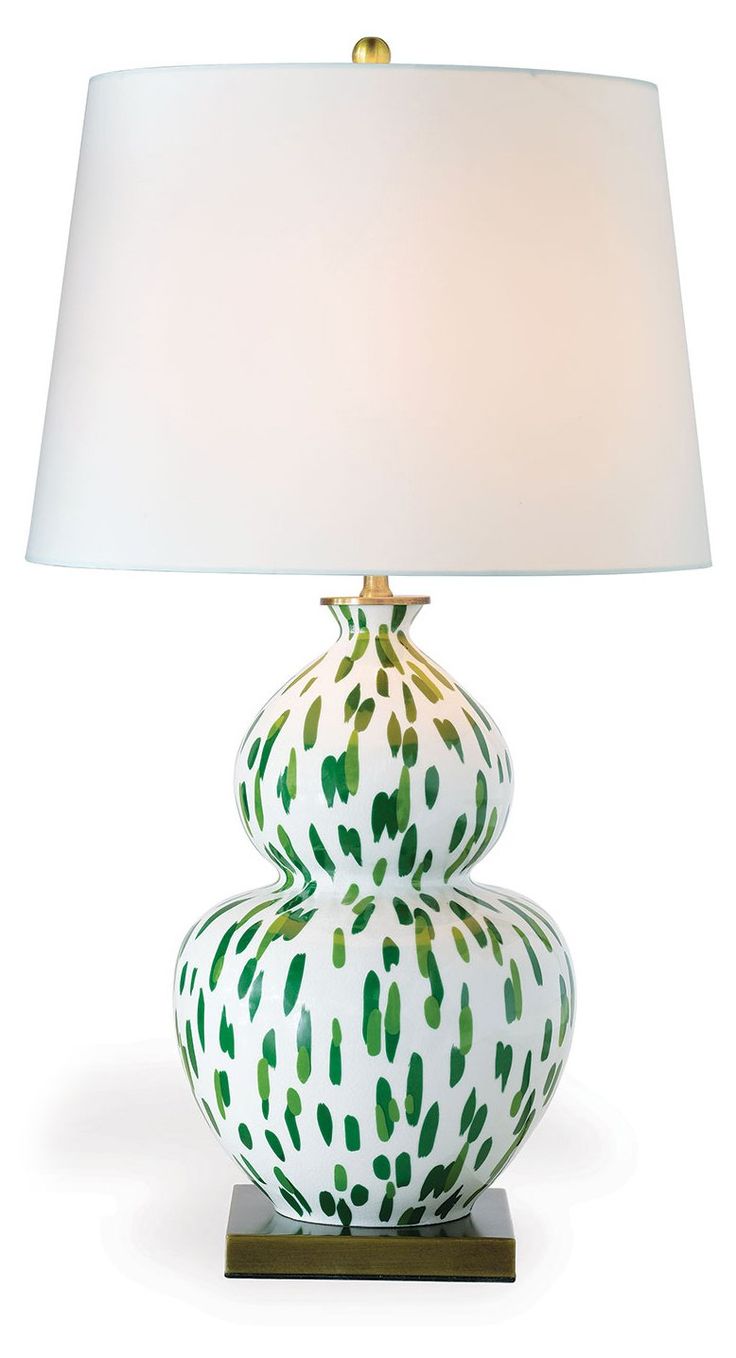 a green and white lamp sitting on top of a table