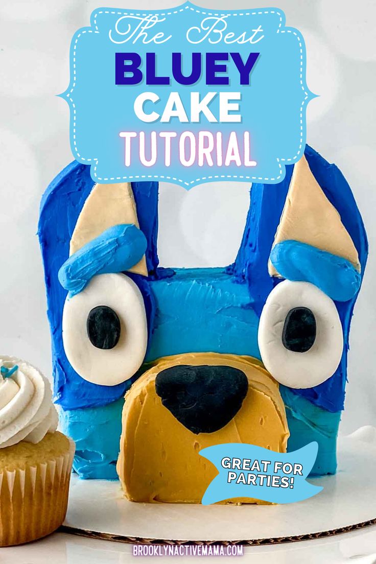 a blue dog cake sitting next to a cupcake