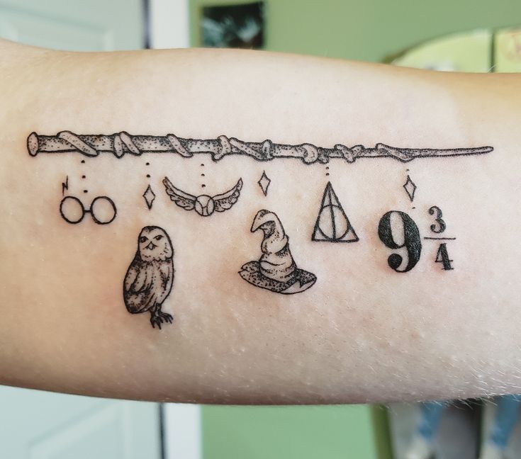 a person with a harry potter tattoo on their arm and an owl holding a wand