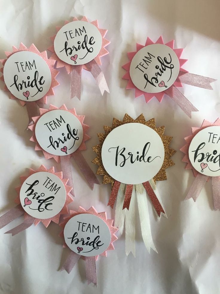 pink and white badges with the words team bride on them