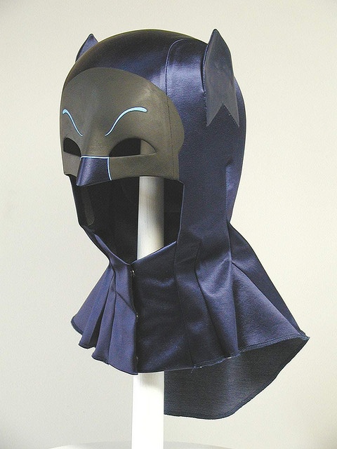 a batman mask on top of a white stand