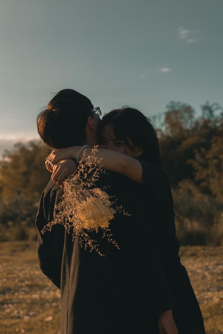 two people are hugging each other outside