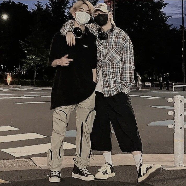 two people standing on the street with masks covering their faces