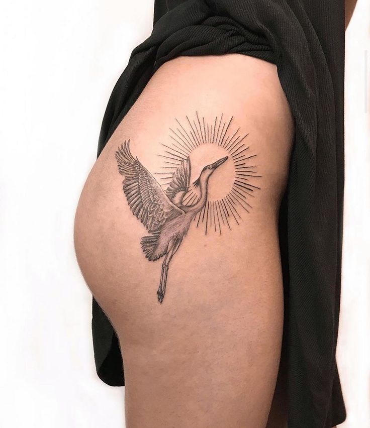 a woman's thigh with a bird tattoo on it