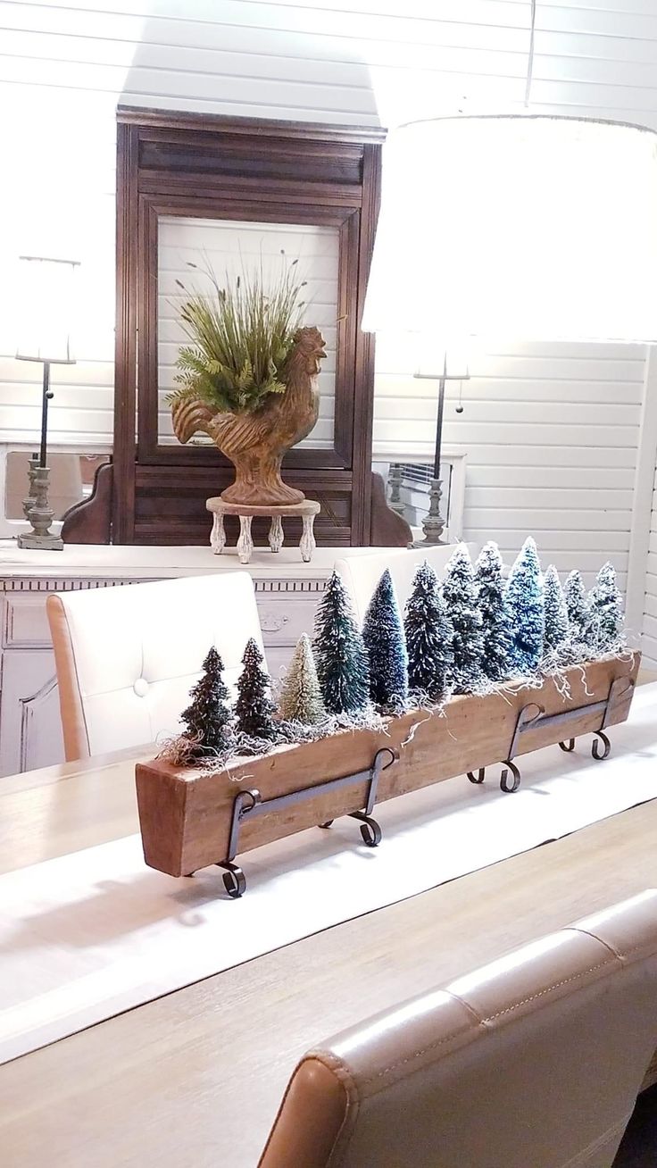 a long table with christmas trees on it in front of a mirror and lamp shade