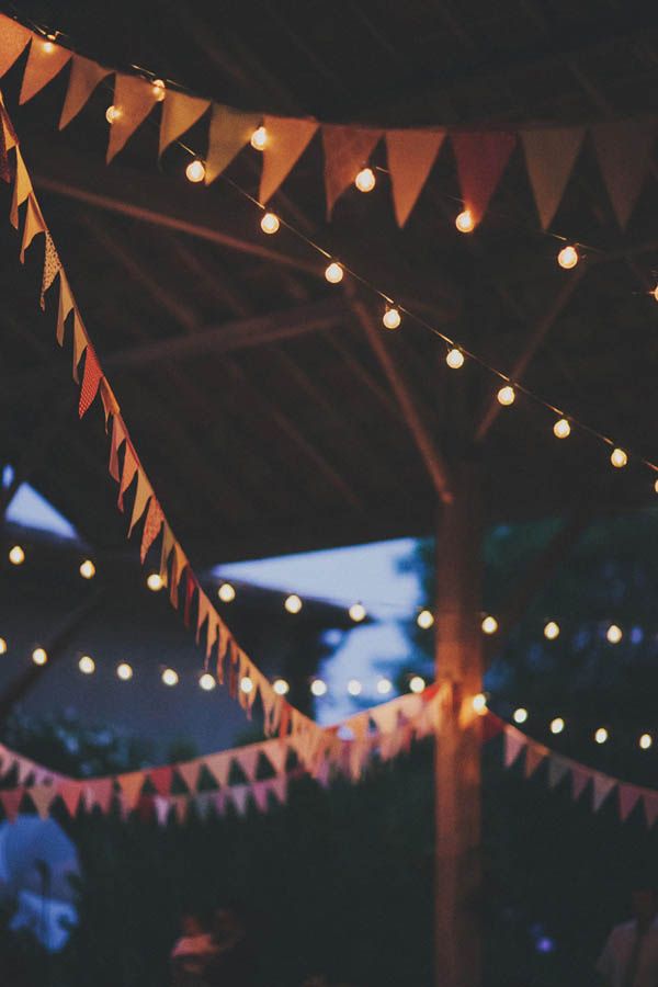 an outdoor event with lights strung from the ceiling