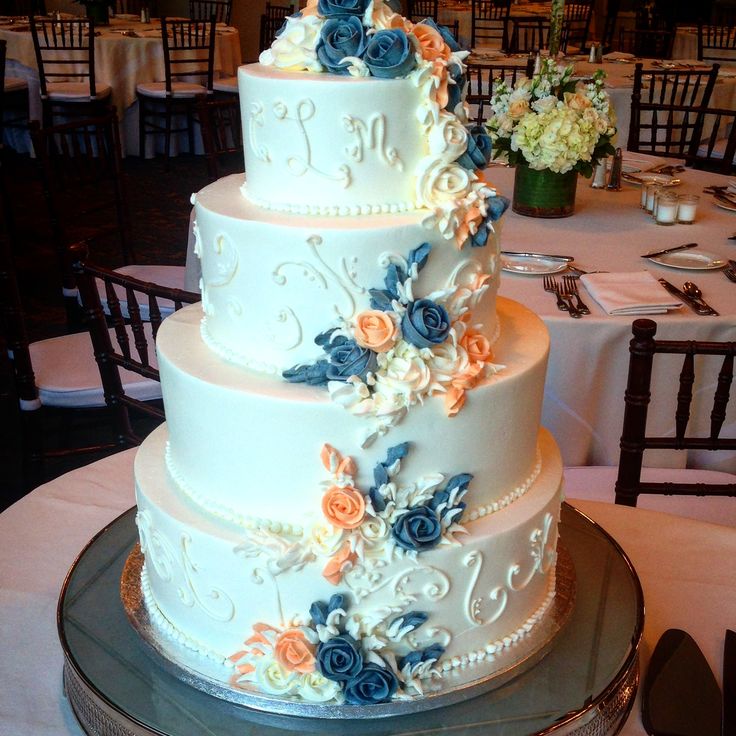 a three tiered wedding cake with blue and orange flowers