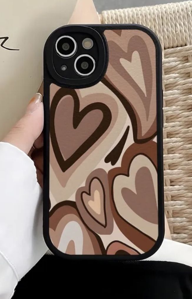 a person holding an iphone case with hearts on it