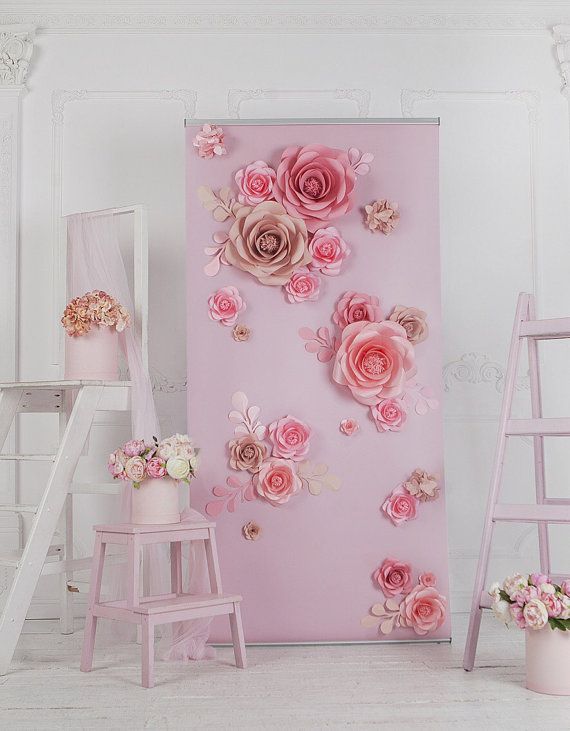 there is a pink wall with flowers on it and two ladders in the background