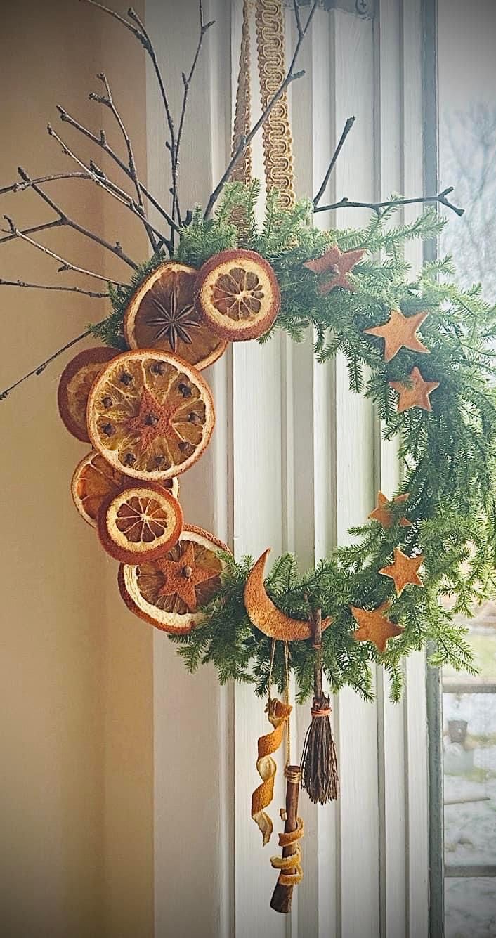 an orange wreath hanging from the side of a window