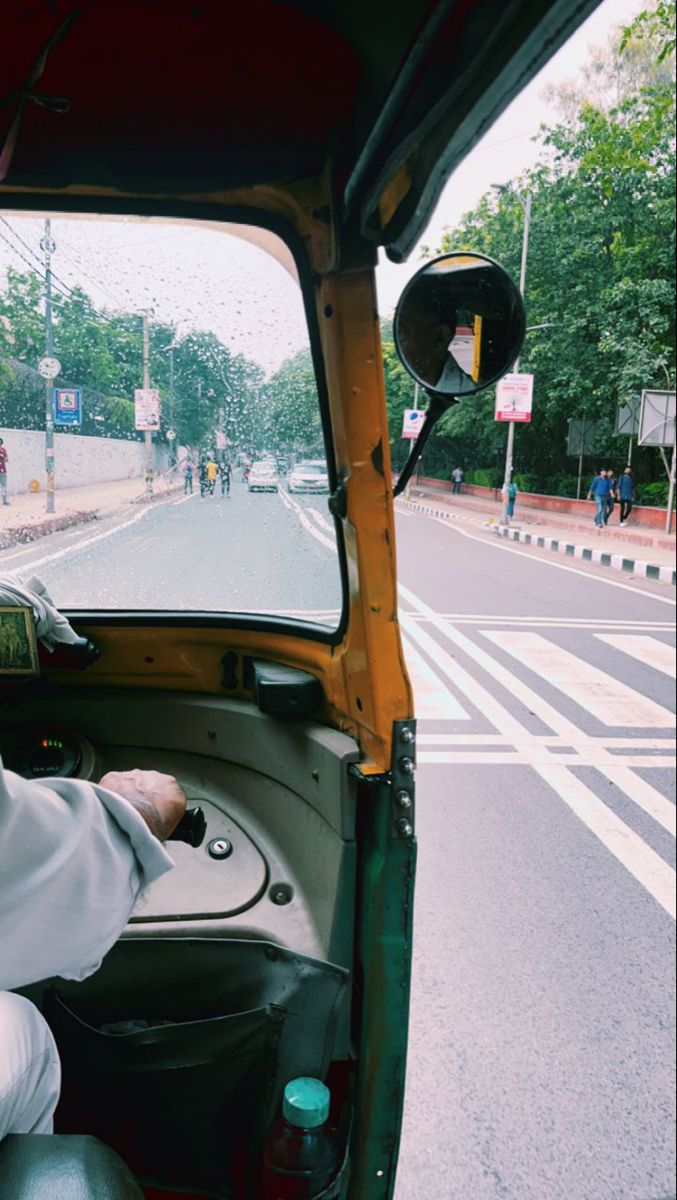 a man sitting in the driver's seat of a truck on a city street