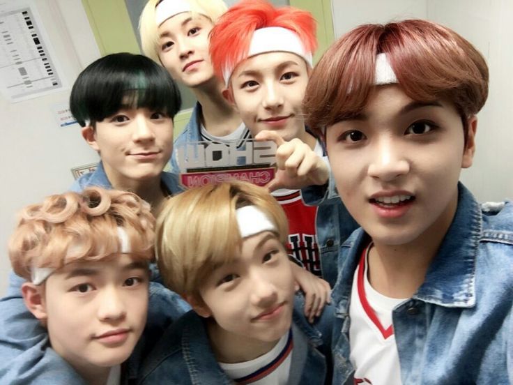 the group of young men are posing together for a photo in front of a mirror