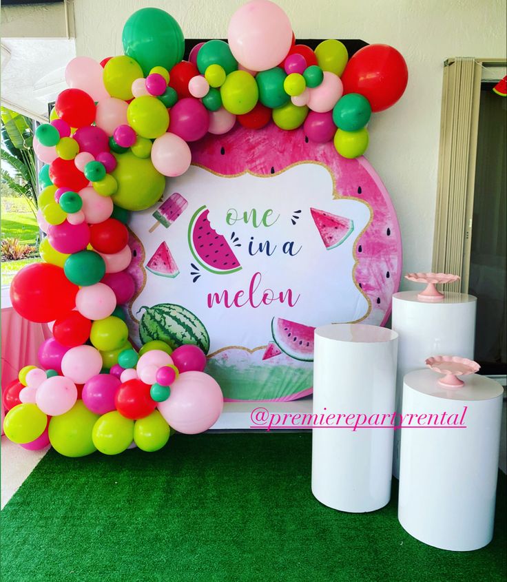 a table topped with balloons and watermelon decorations