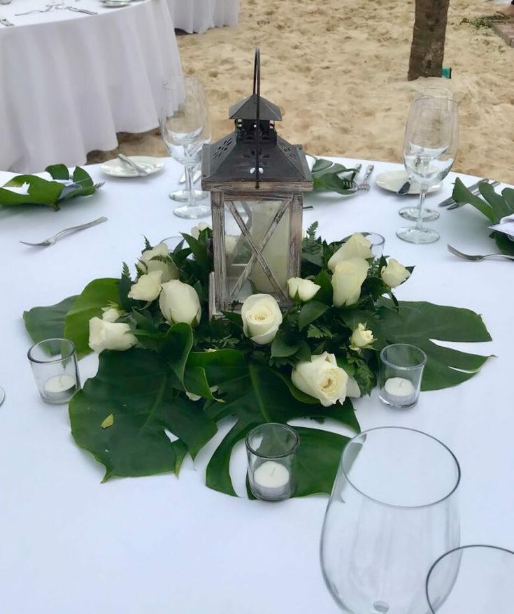 a table with white flowers and greenery on it