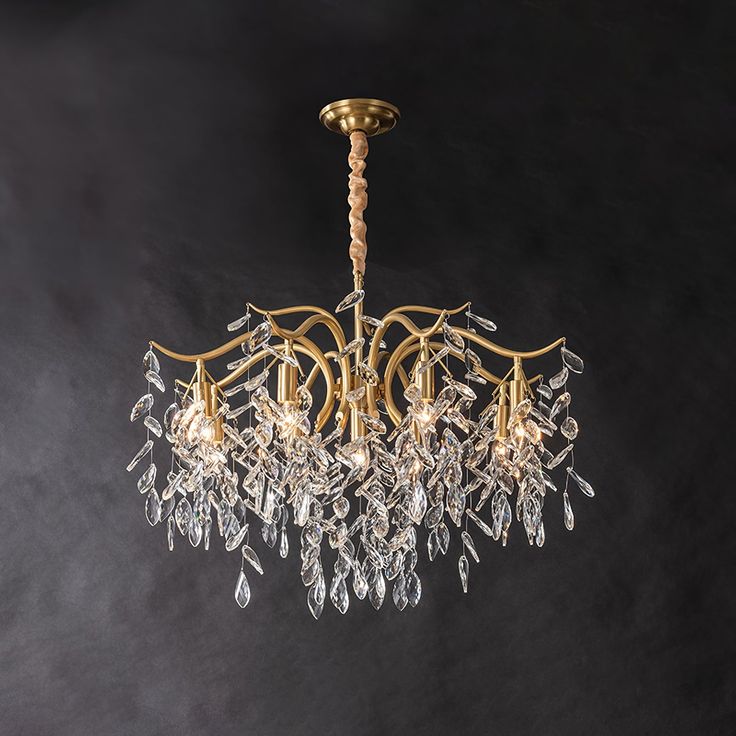 a gold chandelier with crystal drops hanging from it