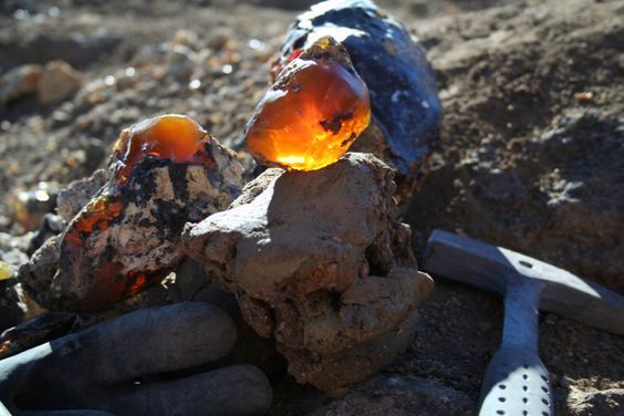 an assortment of rocks and utensils sitting on the ground next to each other