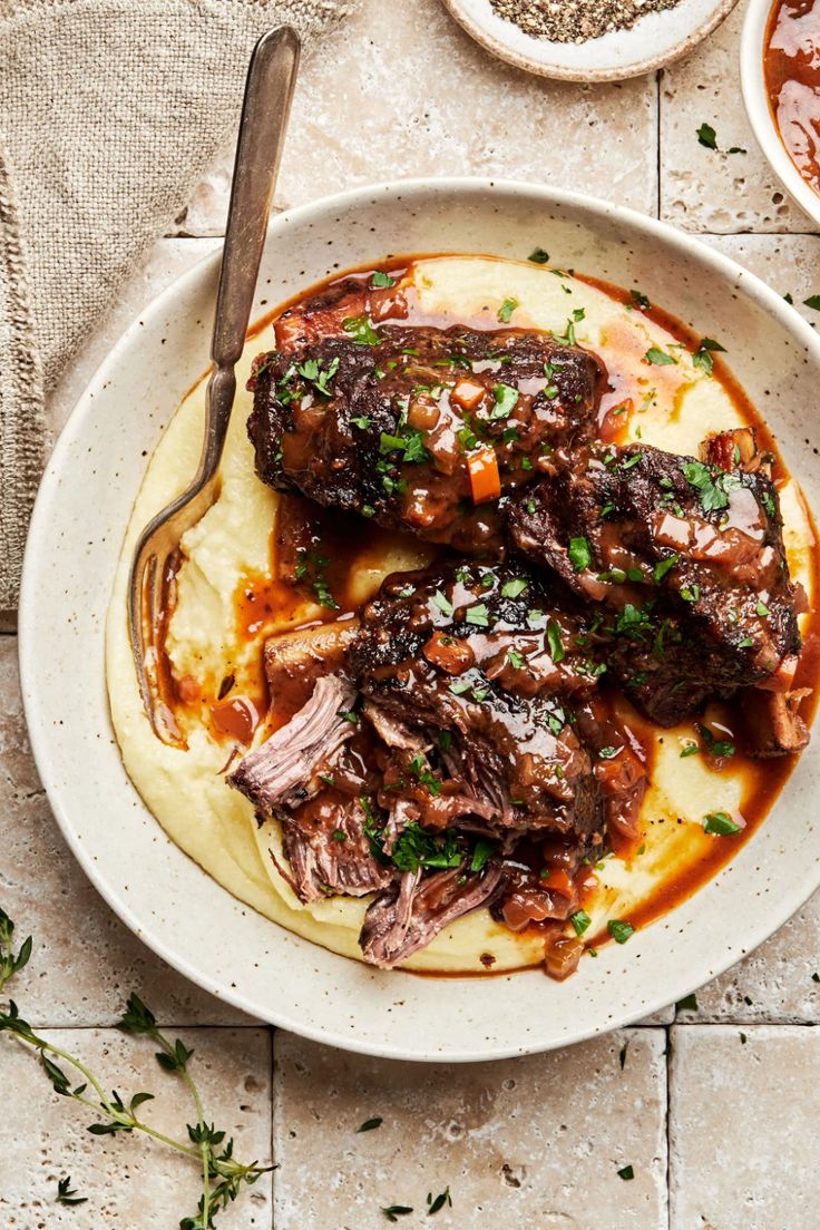 a white plate topped with meat covered in sauce and garnished with parsley