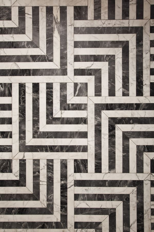 a black and white marble floor with an abstract design in the center that looks like a maze