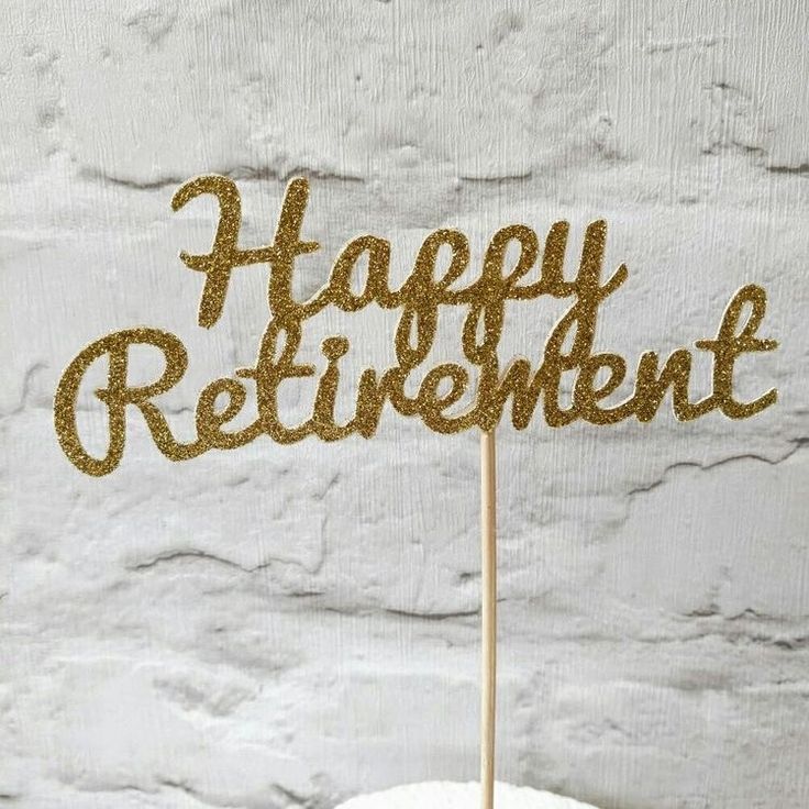 a happy retirement cake topper on a white frosted cake with gold glitter letters