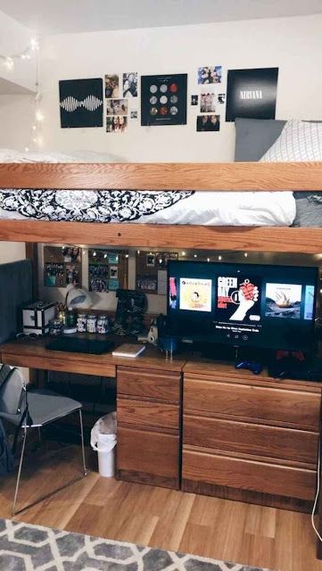 there is a loft bed with a desk and tv in the middle of this room