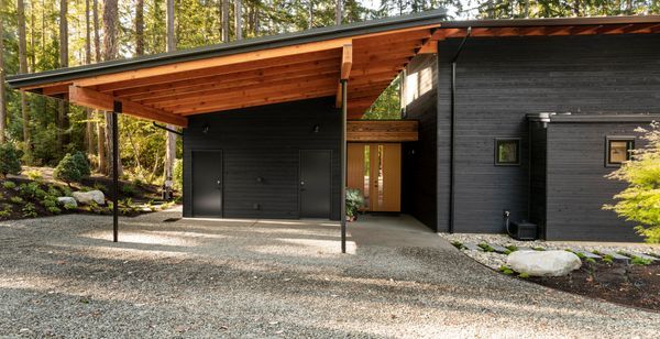 a black house in the middle of a forest