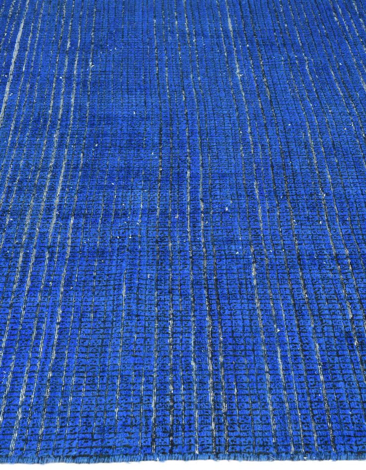 a blue rug with white lines on the top and bottom, is shown in full view