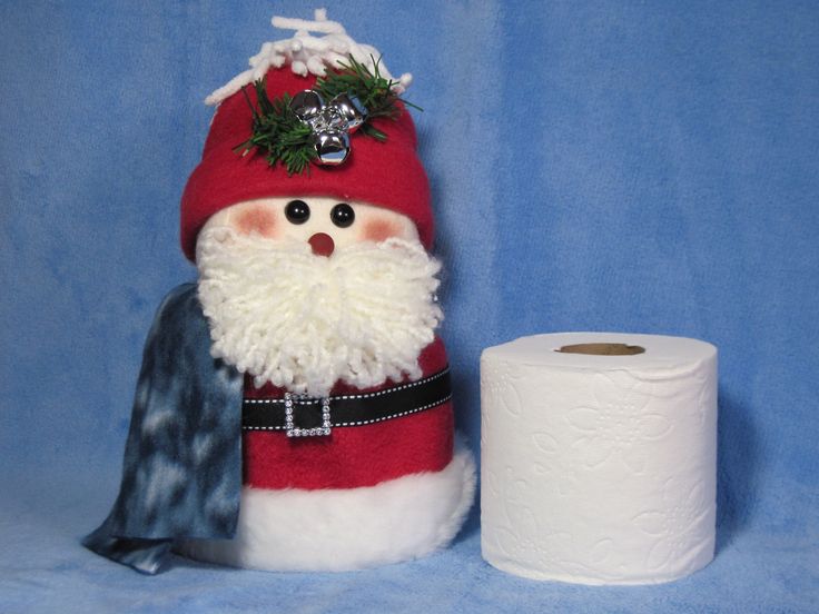 a santa clause doll next to a roll of toilet paper on a blue background,