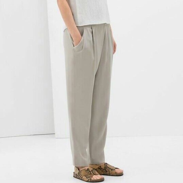 Zara Relaxed Draped Front Trousers In Sand.....Size S. Slinky Soft Weave; 100% Lyocell. Light Grayish Beige/Ivory/Stone. Crossover Draped Pleated Front. Elasticized Waistband At Back. Side Zipper Closure. Slanted Front Pockets. Relaxed Tapered Legs. Waist Across 14.25". Front Rise 10.75". Hip Across 20.75". Inseam 27.5". Leg Opening 6.25" Across. New With Tag. Zara Tapered Leg Bottoms In Solid Color, Elegant Gray Bottoms For Spring, Chic Gray Relaxed Fit Bottoms, Baggy Gray Pants For Spring, Gray Baggy Pants For Spring, Chic Gray Ankle-length Pants, Chic Gray Pants For Spring, Gray High-waisted Pants For Spring, Spring Gray High-waisted Pants