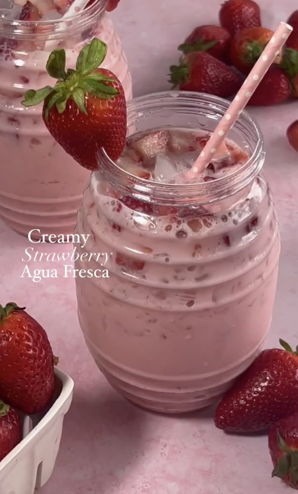 two mason jars filled with ice cream and strawberries