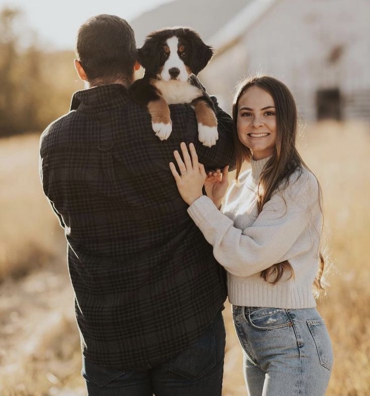 a man and woman holding a dog in their arms