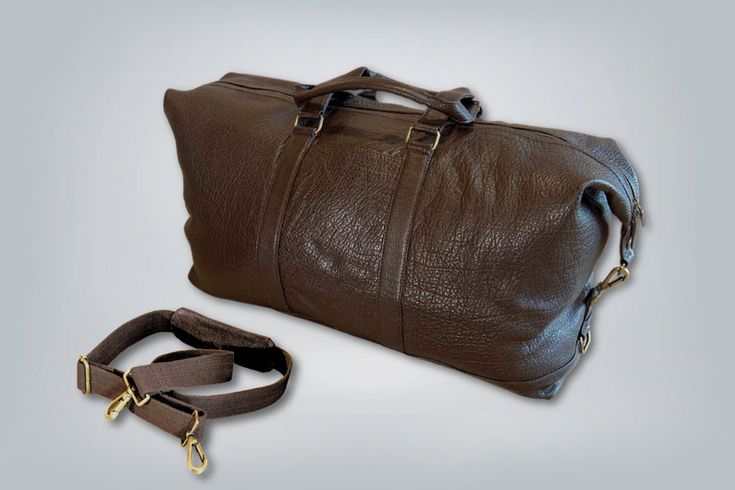 "Manchester Magnum Duffle Introducing our Extra-Large shrunken water buffalo bag. A unique blend of style and practicality. Made from the highest quality of shrunken water buffalo leather, this bag exudes an air of timeless elegance. The shrunken leather not only adds a distinctive texture but also ensures durability and resilience, promising years of reliable use.  With its surprisingly spacious design this duffle is a perfect companion for all your travel needs.  It has ample room for all your Brown Rectangular Bag With Grained Texture, Brown Grained Texture Rectangular Bag, Formal Brown Bag With Grained Texture, Classic Brown Bag With Grained Texture, Brown Bags With Grained Texture For Daily Use, Brown Leather Bag With Grained Texture, Brown Grained Texture Bag For Daily Use, Rectangular Leather Bag With Grained Texture, Brown Travel Bag With Grained Texture