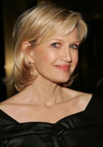 a woman with blonde hair wearing a black dress and looking off to the side at an event