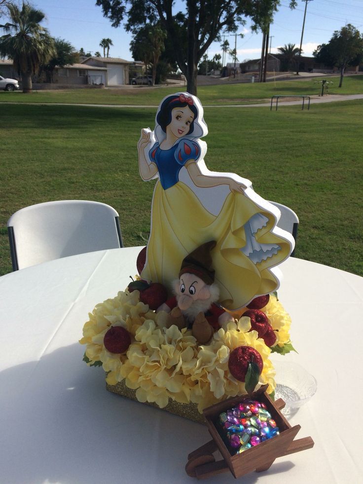 there is a cake that looks like snow white and the seven dwarfs on top of it