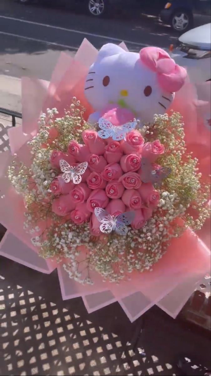 a hello kitty bouquet with pink roses in it