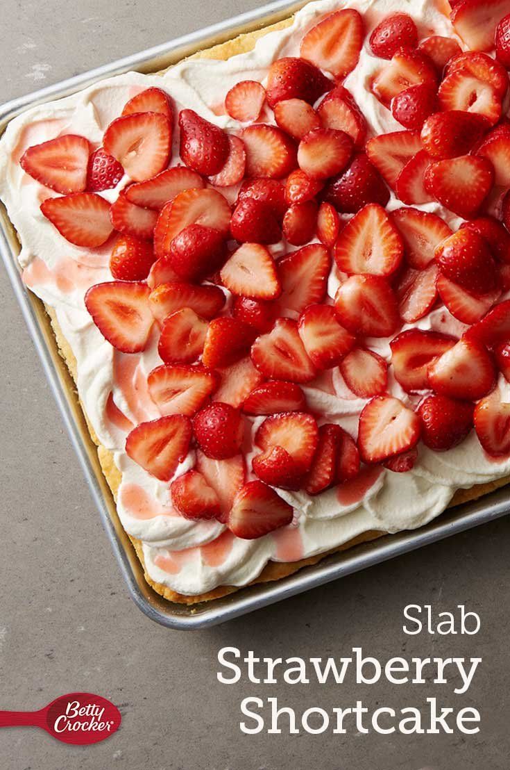 a strawberry shortcake with whipped cream and sliced strawberries on top, in a pan