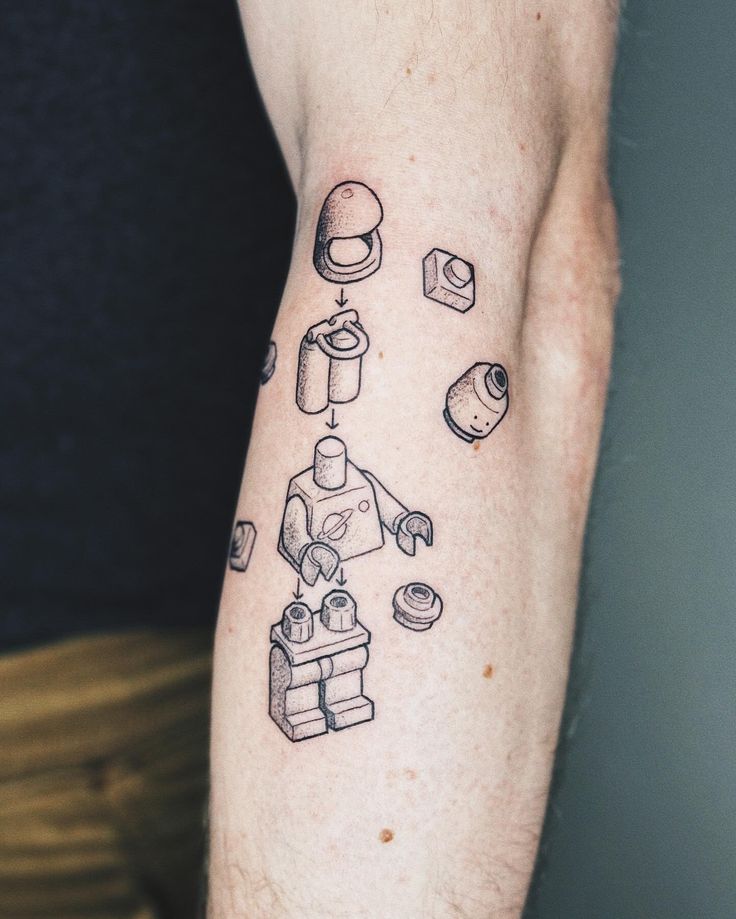 a man's arm with an outline of a lego figure and objects on it