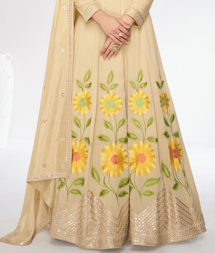 COLOR : Dull Yellow Cream FABRIC : Gown & Dupatta - Premium Silk WORK : Resham Embroidery, Hand Work, Sequins, Floral Motifs, Lace Border OCCASION : Wedding, Reception, Mehendi, Party Wear, Festival READY-TO-WEAR : No STITCHING : Available as semi-stitched fabric, can be stitched using standard size option (+$30). Note: There might be a slight color variation due to lighting and flash used during photoshoot. The bright shade seen is the best closer view of fabric's color. Navratri Floor-length Sets With Floral Embroidery, Anarkali Set With Floral Embroidery, Floor-length Gown With Dori Work For Diwali, Bollywood Style Floral Embroidered Churidar For Reception, Festive Floor-length Sets With Floral Embroidery, Floor-length Chanderi Sharara With Floral Embroidery, Semi-stitched Maxi Lehenga With Intricate Embroidery, Embroidered Floor-length Lehenga For Eid, Unstitched Churidar With Floral Embroidery For Reception