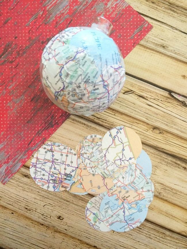 two pieces of paper are sitting on a wooden table next to an ornament