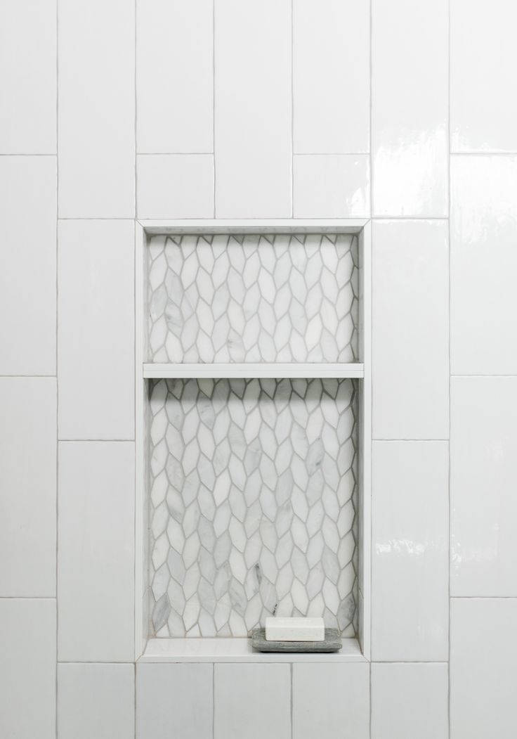 a white tiled bathroom with a window in the wall