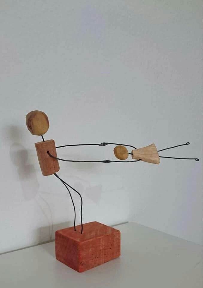 a wooden sculpture with two stick figures on it